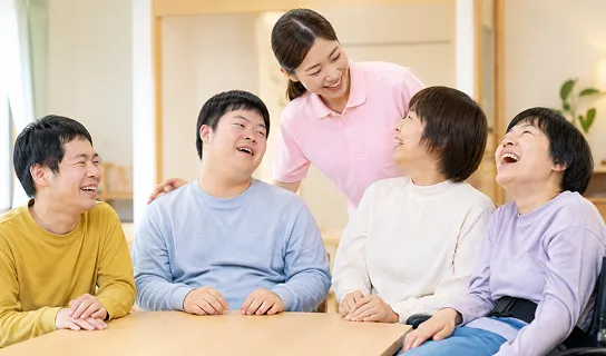 テーブルで談笑する利用者とスタッフ
